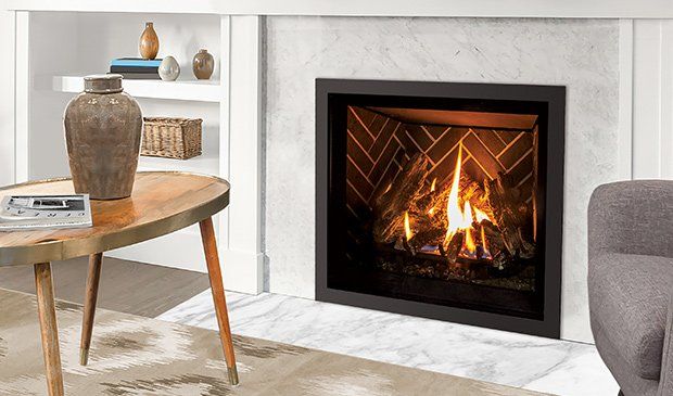 Fireplace with lit flames and brick interior, framed in black, sitting in a marble hearth.