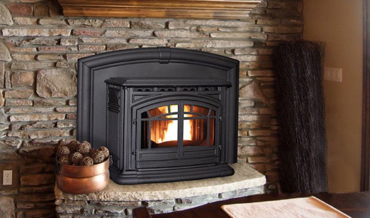 Black pellet stove in stone fireplace with burning flames.