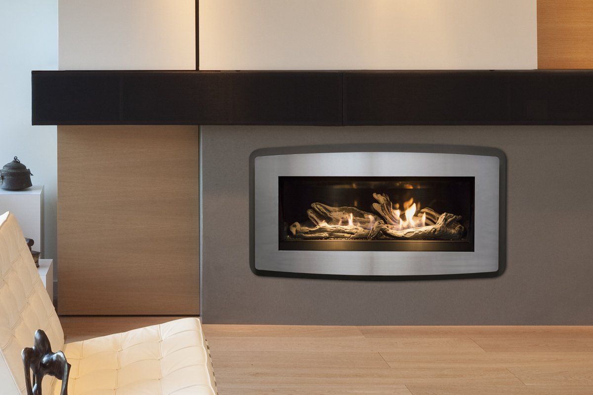 Modern fireplace with stainless steel frame, glowing flames, set in a gray wall.