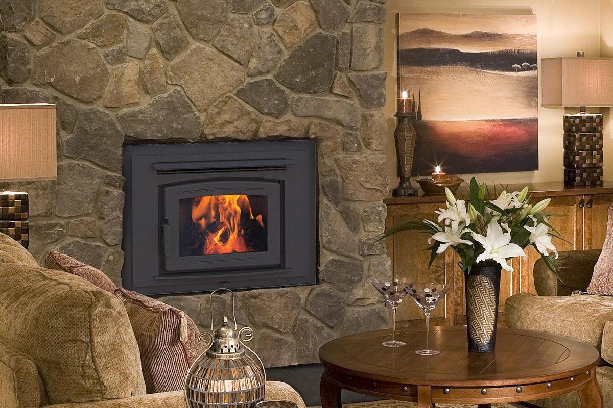Fireplace set in stone wall with fire burning, surrounded by furniture and decor.