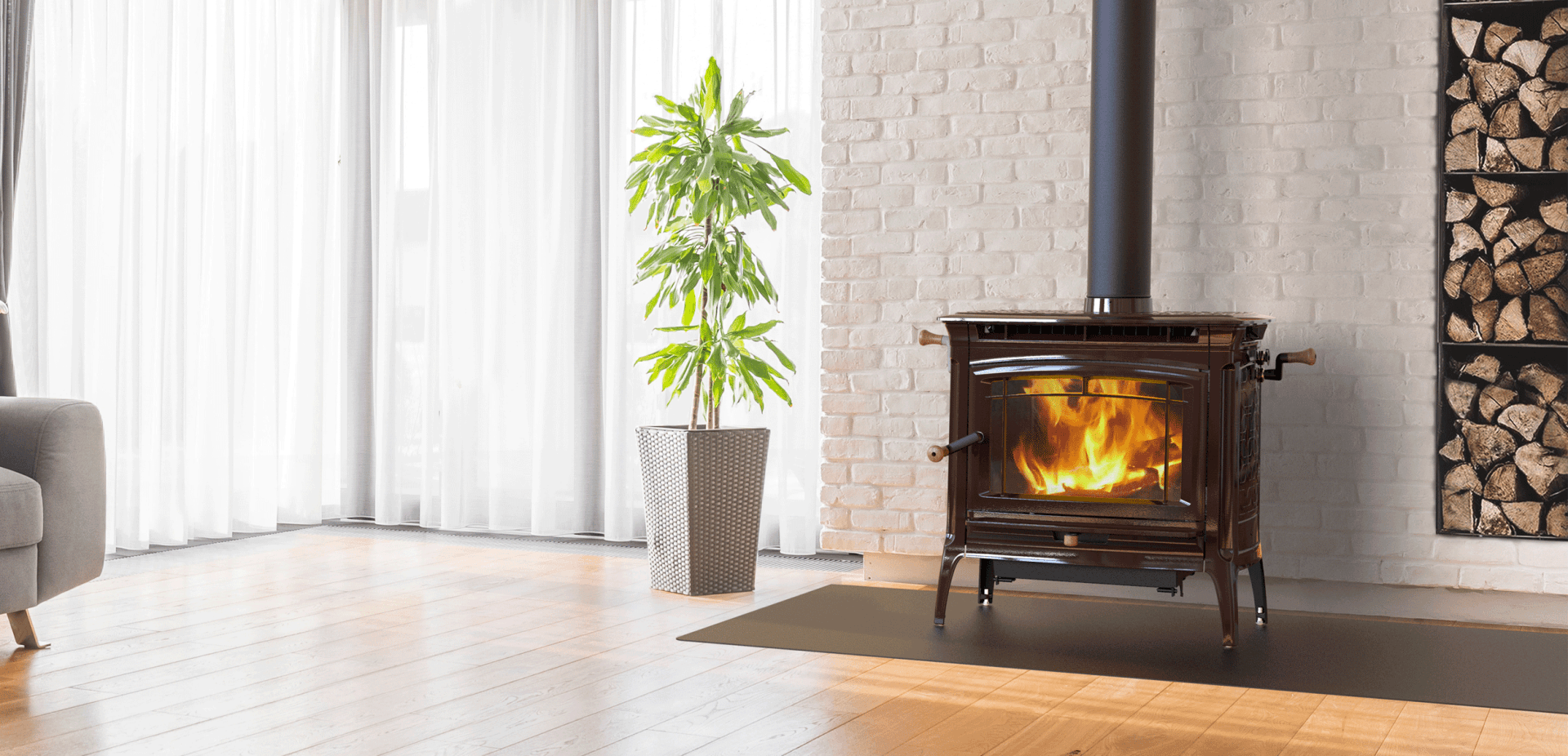 Cozy living room with a lit fireplace, firewood, and a potted plant by a window.
