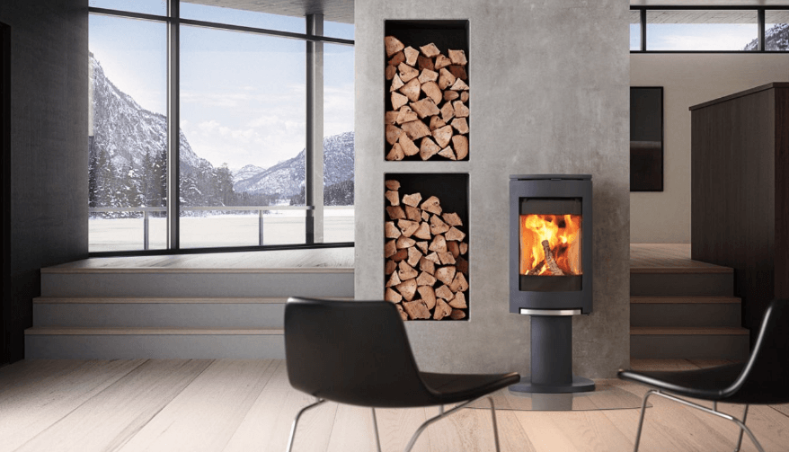 Modern living room with fireplace, wood storage niches, and a snowy mountain view.