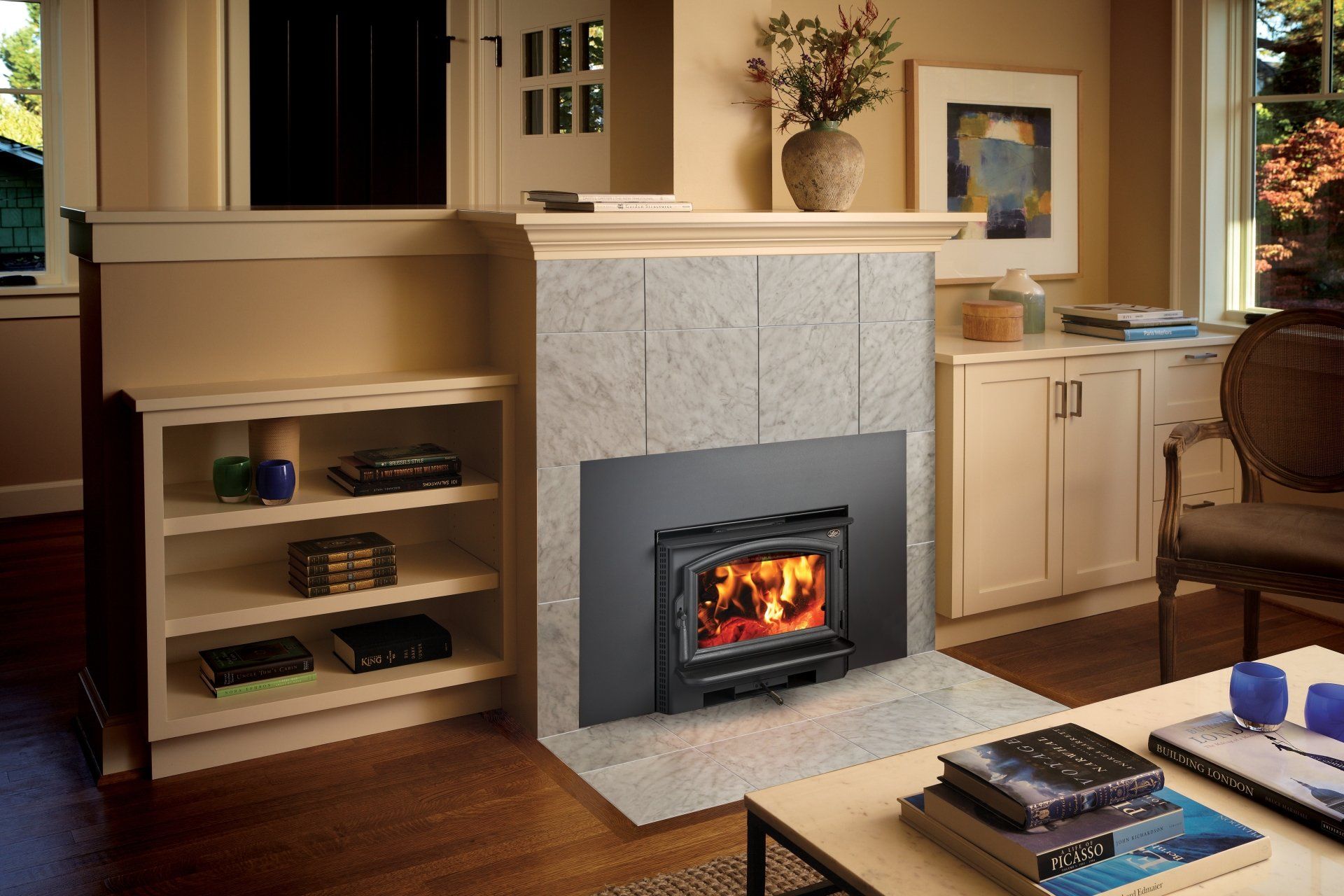 Fireplace with stone surround in a living room, built-in shelves, and a coffee table.