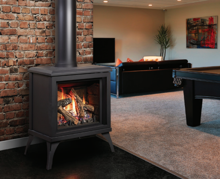 Black gas fireplace with flames, chimney against a brick wall, in a living room with pool table and couch.