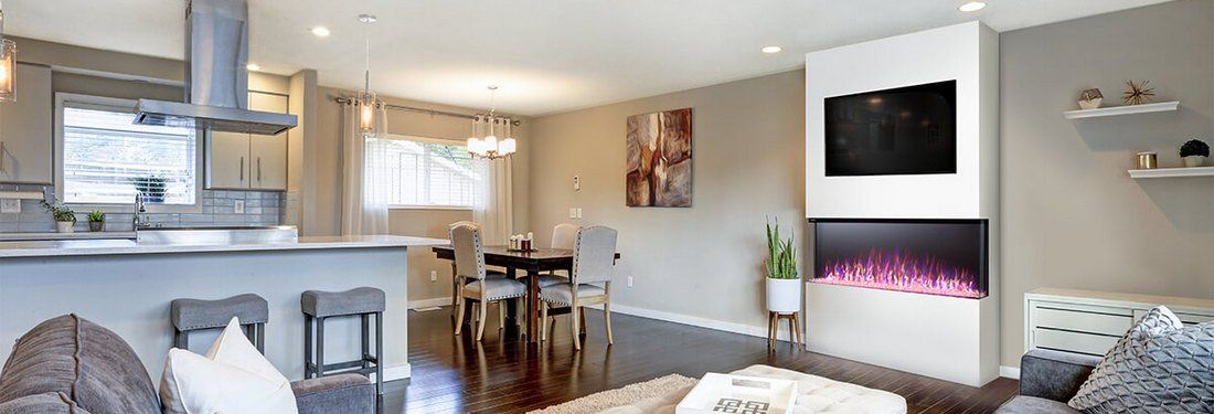 Open-concept living space with kitchen, dining area, and fireplace with TV.