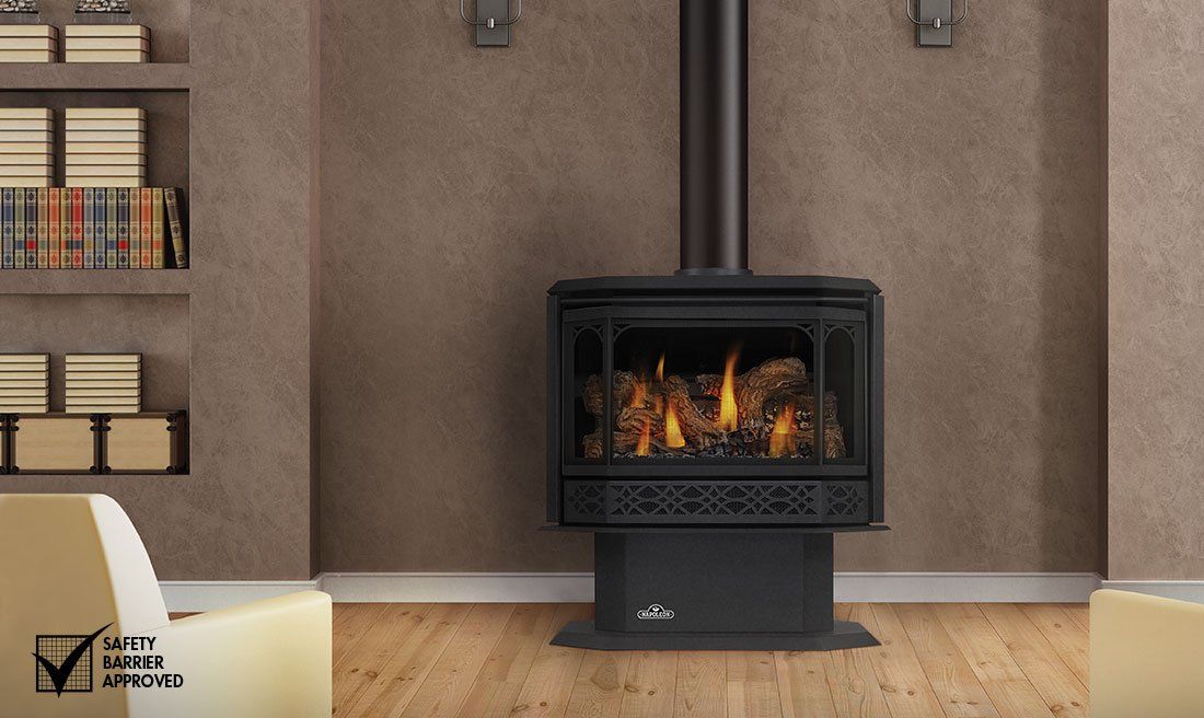 Black gas fireplace with flames, in a room with wood flooring and shelves.