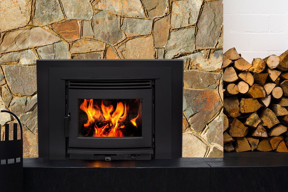 Black fireplace with fire, stone wall background, and firewood stack.