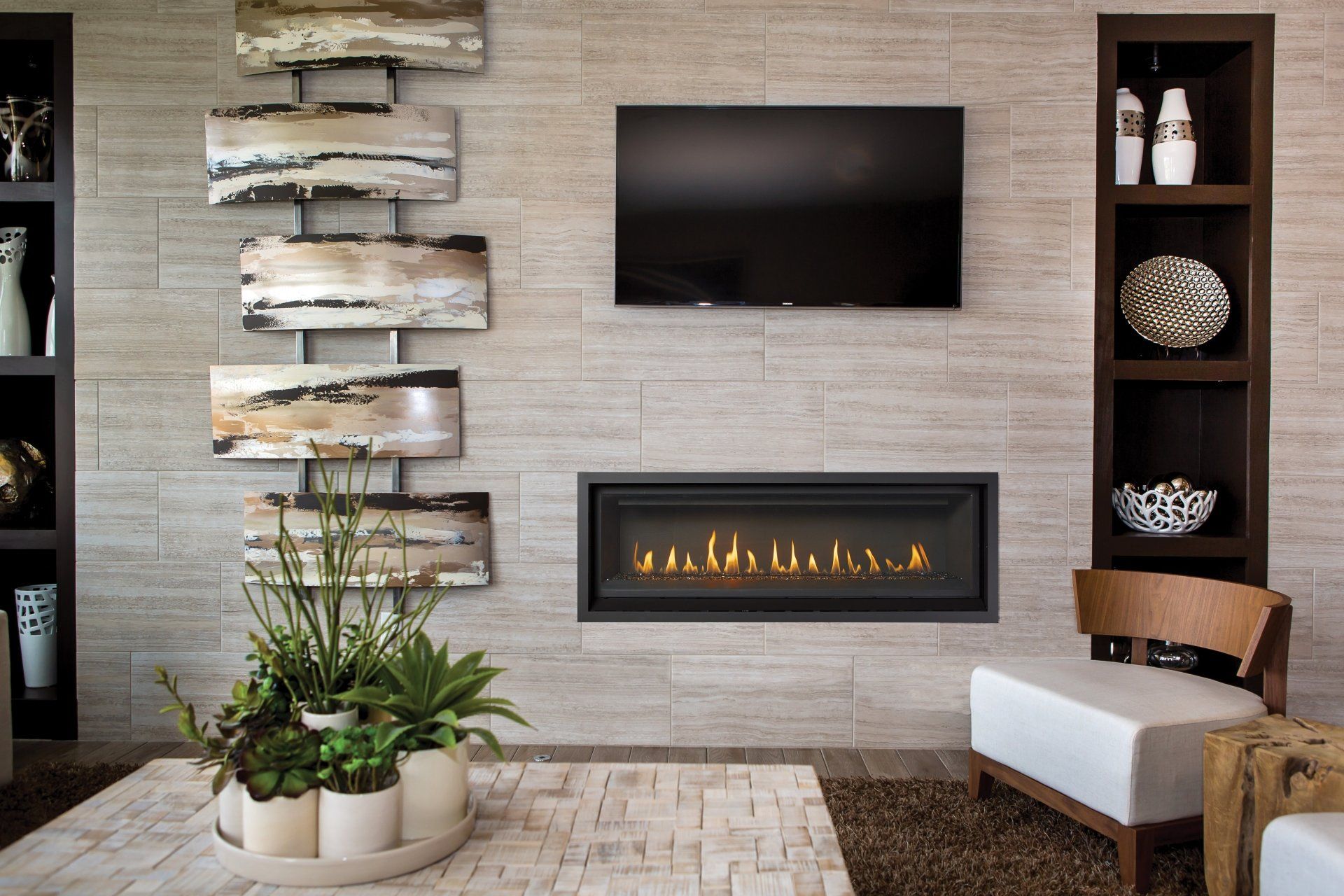 Living room with fireplace, TV, and decorative wall art on a textured neutral wall.