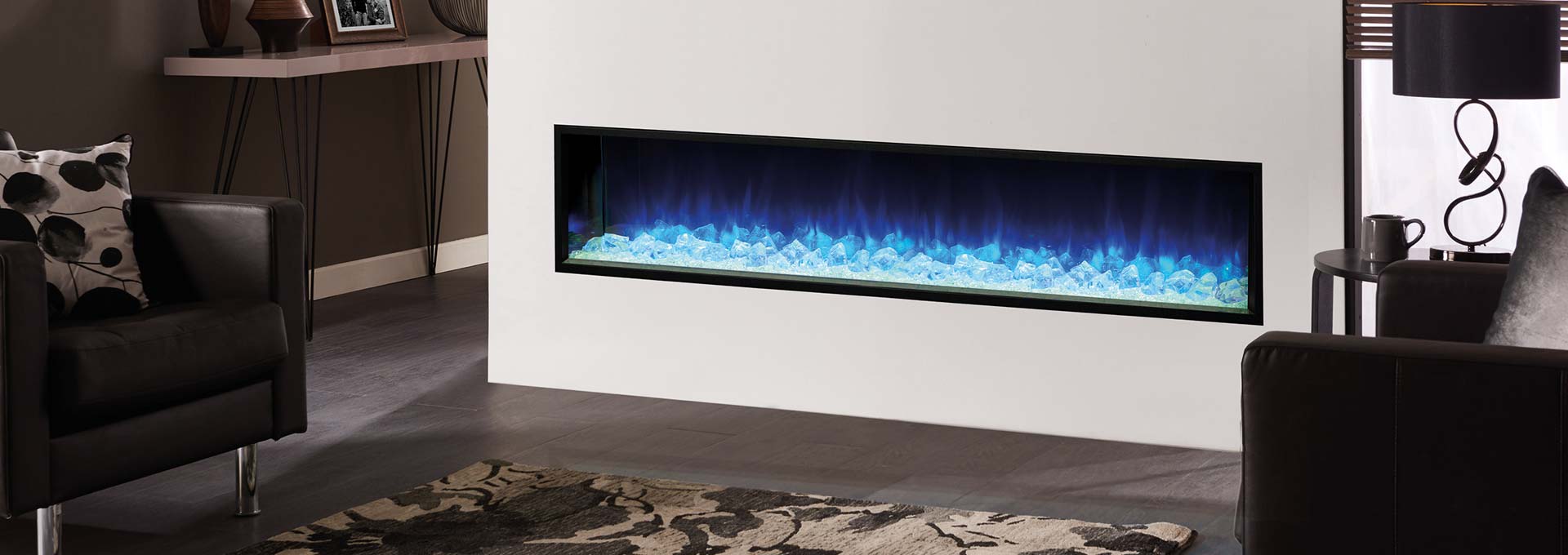 Modern living room with a built-in fireplace emitting blue flames between two armchairs.