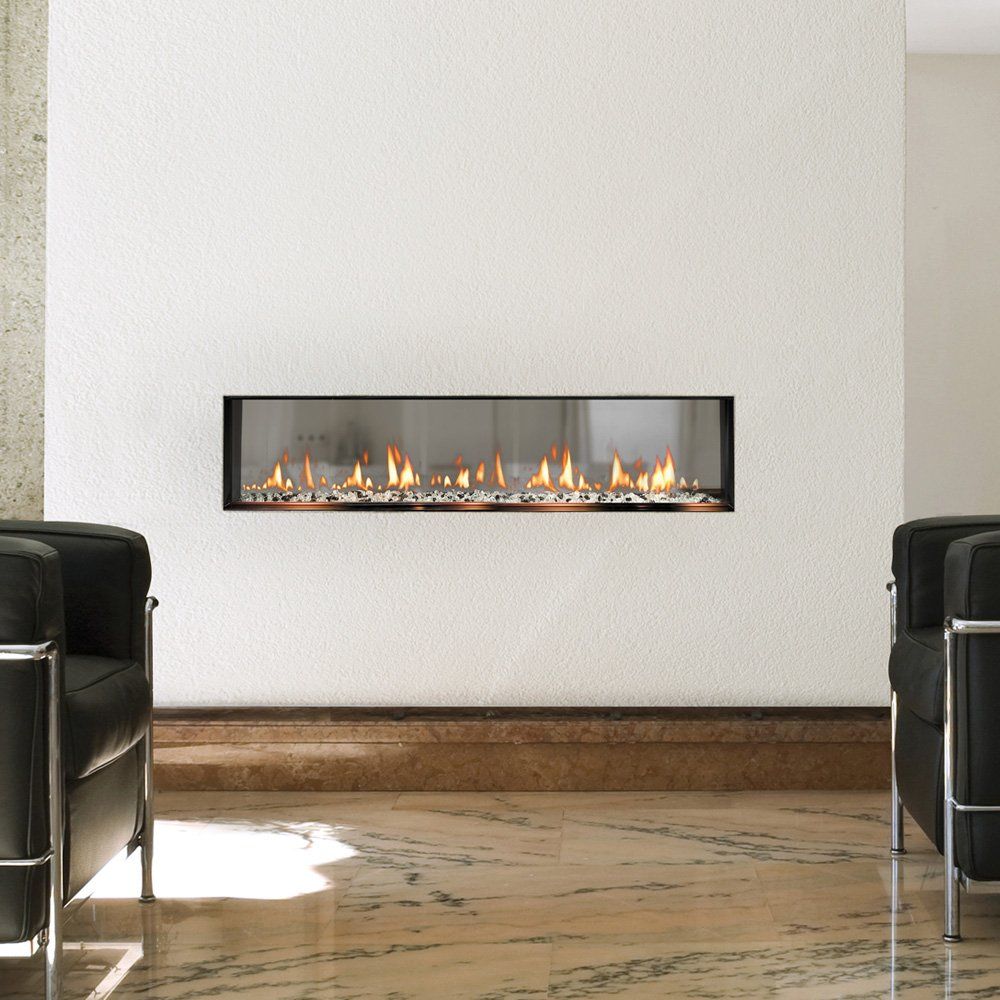 Modern fireplace built into a white wall, flames visible, flanked by black chairs.