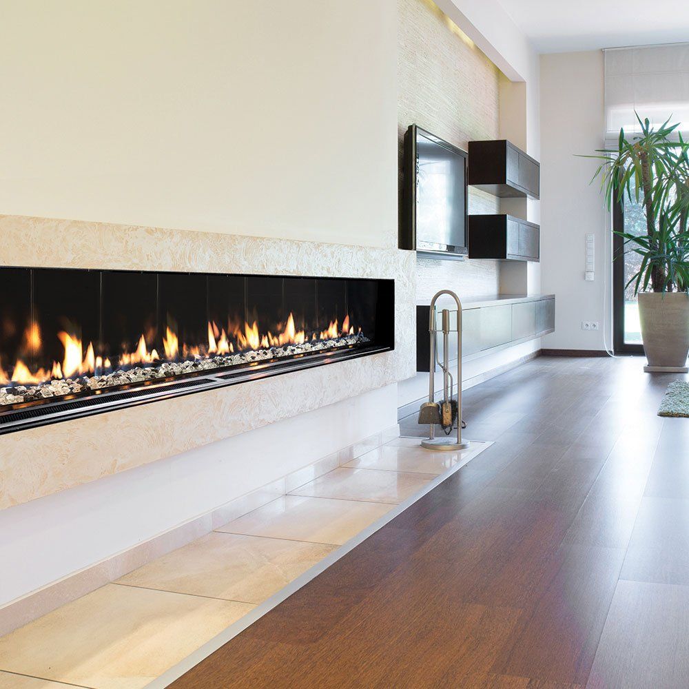 Modern living room with fireplace, TV, and plant. Long, linear fireplace with flames against white wall.