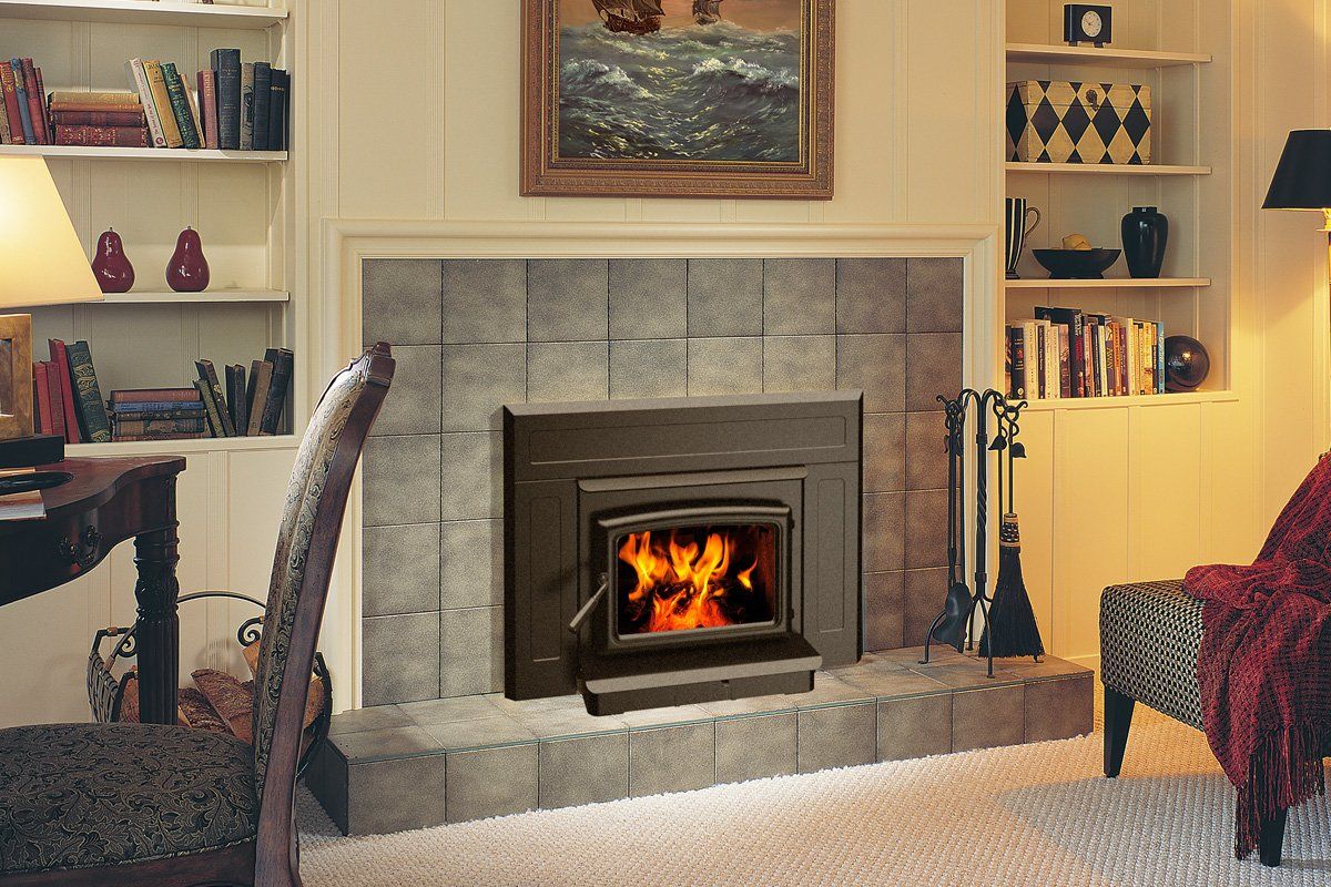 Fireplace with burning flames, set against a tiled backdrop.  Built-in shelves on each side; cozy interior.