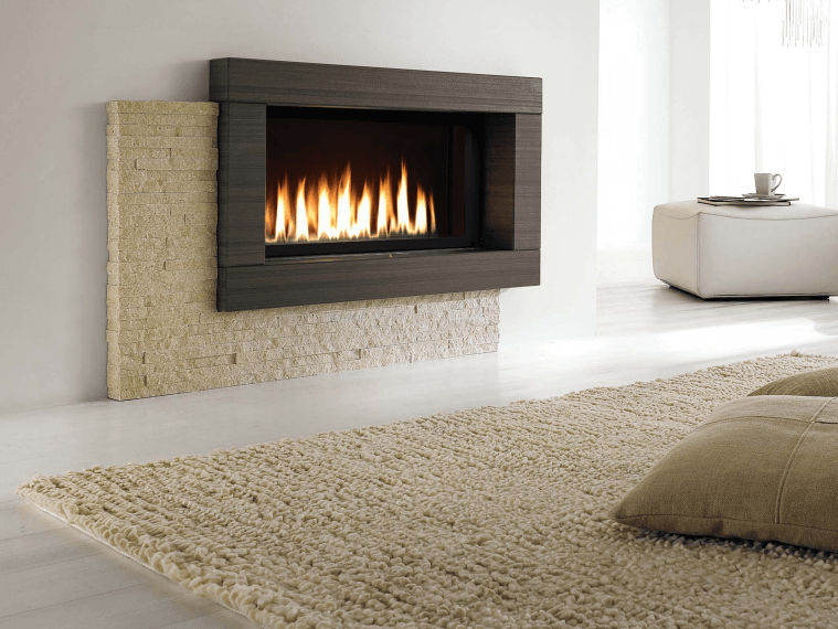 Modern gas fireplace with dark wood frame and beige stone surround, flames visible, on white wall.