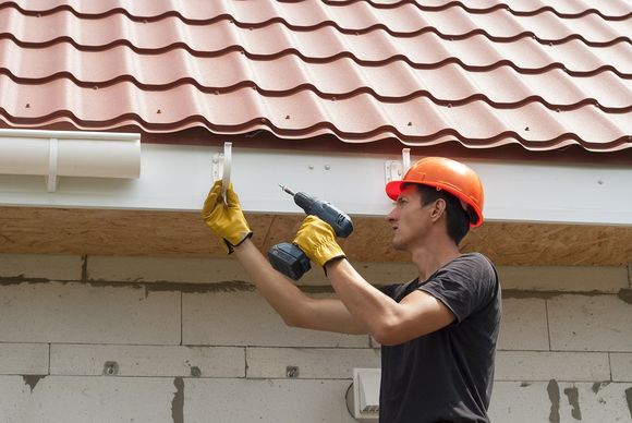 contractor installing house gutter