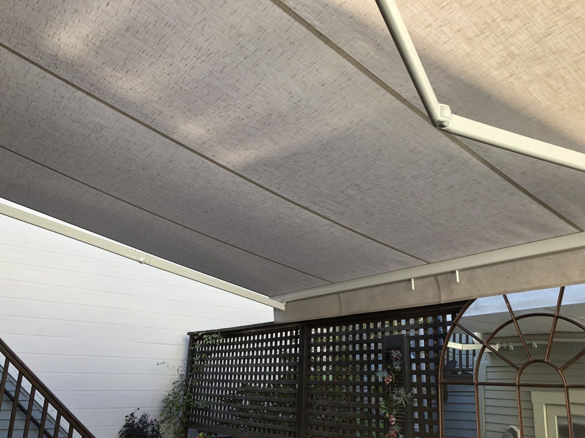 A white awning is hanging from the ceiling of a balcony.