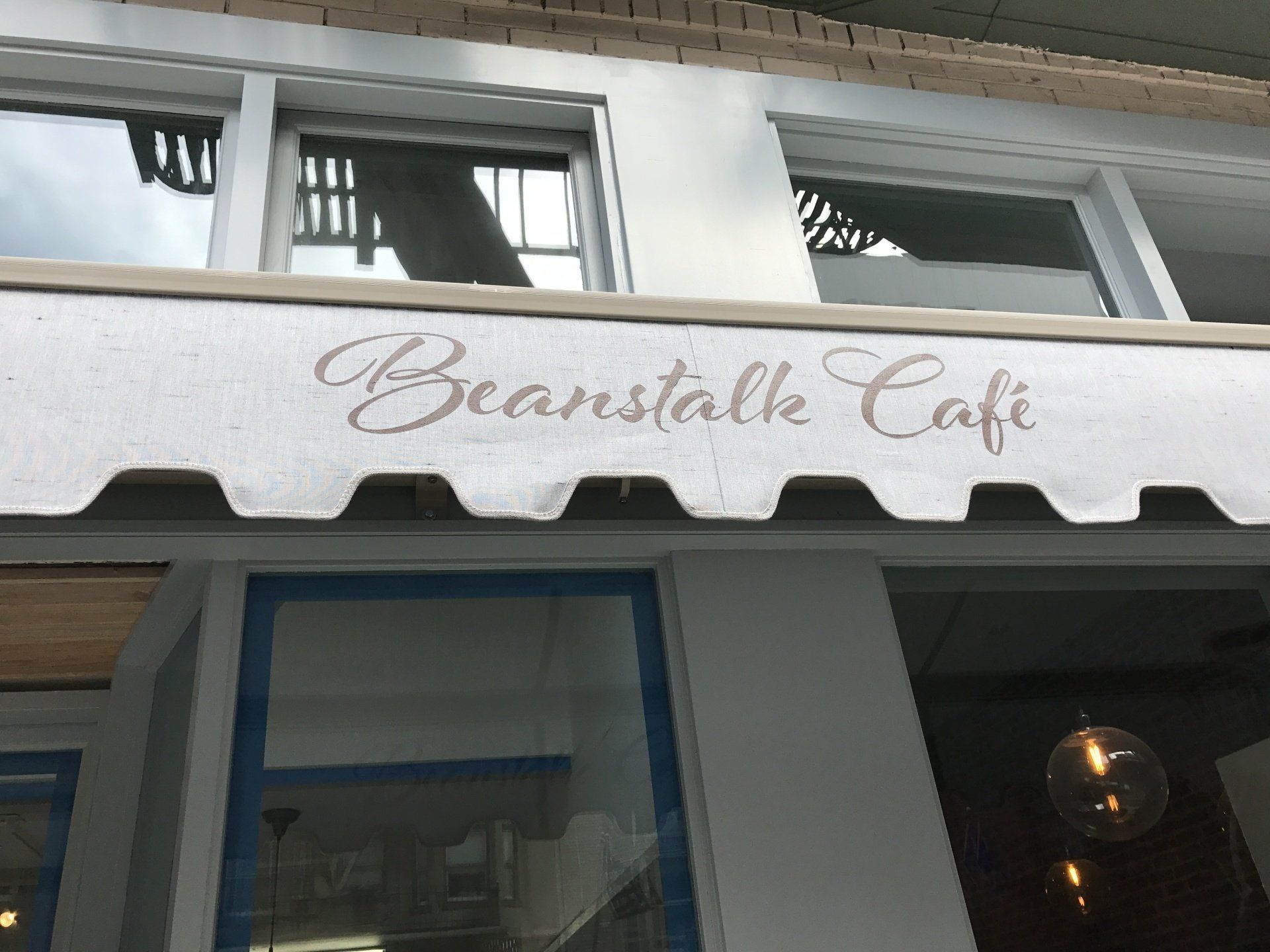 A white awning with the word beanstalk cafe on it