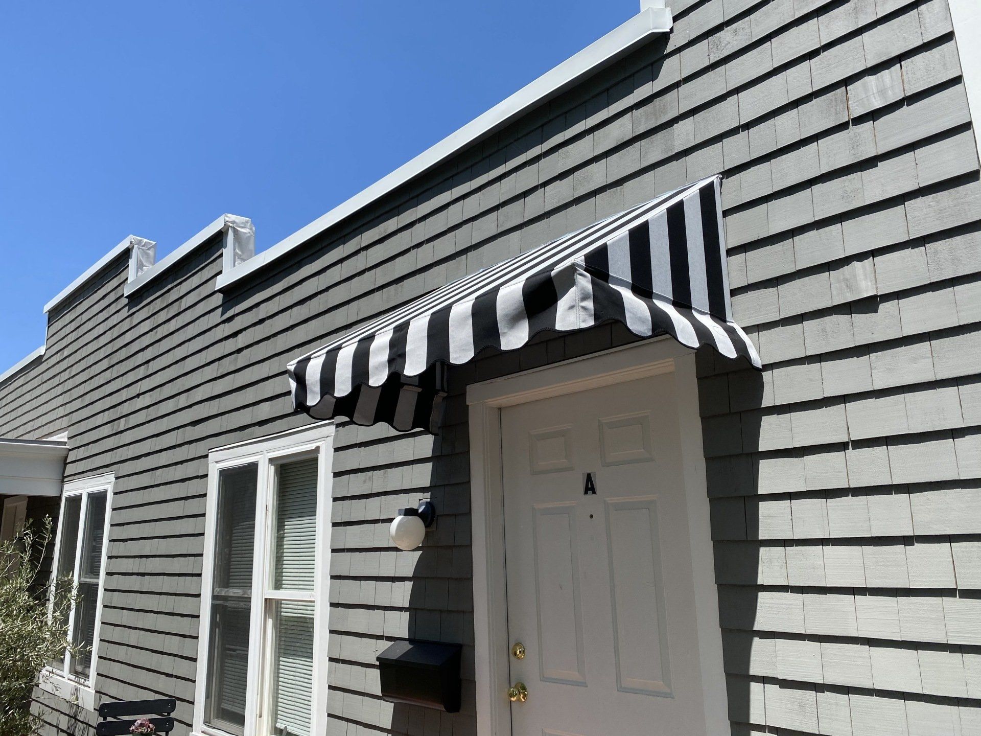 A house with a black and white awning over the door