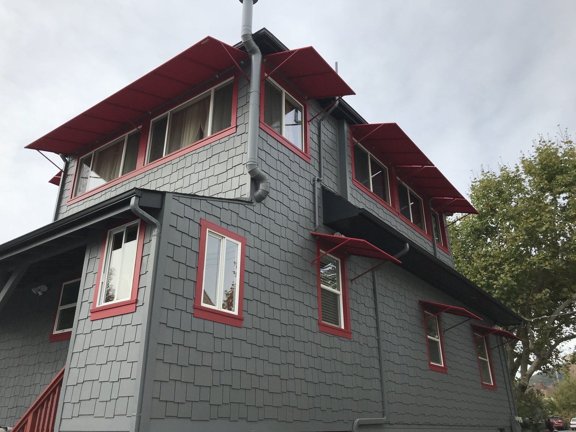 A large gray house with red trim and windows