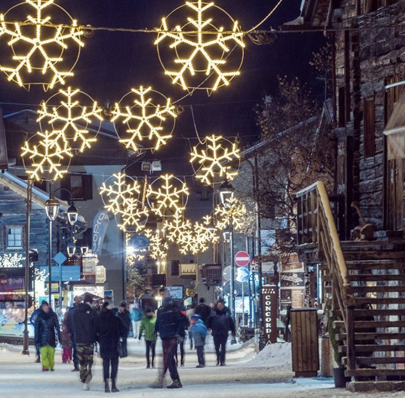 Un gruppo di persone cammina lungo una strada innevata di notte