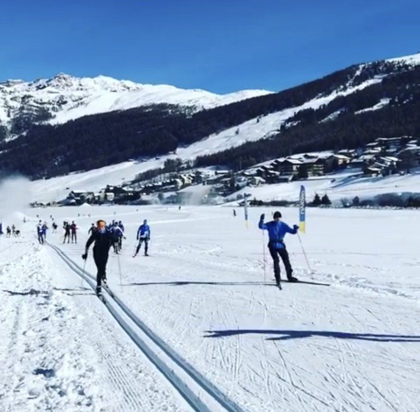Persone che sciano su un pendio innevato con le montagne sullo sfondo