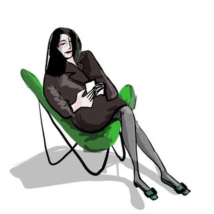 Art historian Tanja Pol sitting in a green Hardoy Butterfly Chair looking into her phone, wearing her fave Vivier shoes.