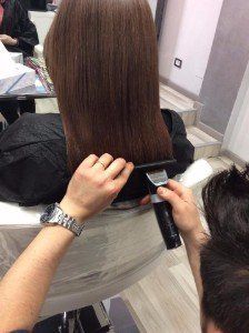 Parrucchiera mette in piega in capelli di una cliente