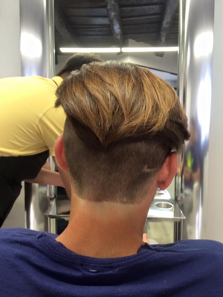 uomo con capelli castani rasati sotto e lunghi sopra