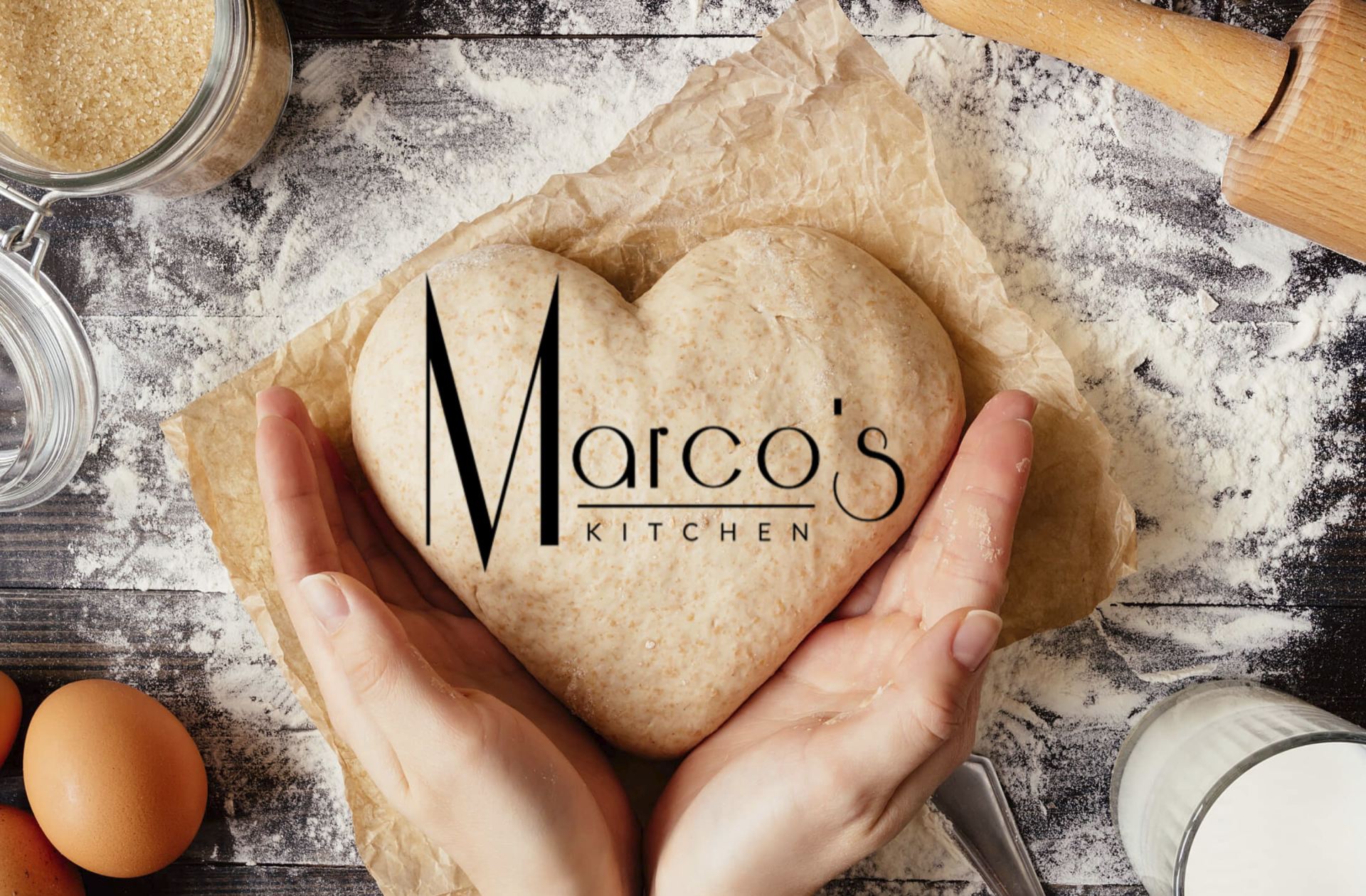 A person is holding a heart shaped dough in their hands.