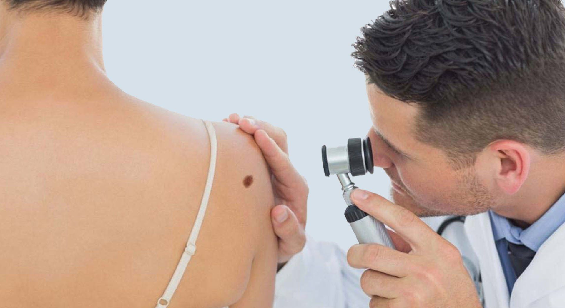 Un médico examina la espalda de una mujer con una lupa.