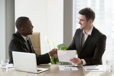 Smiling entrepreneurs shaking hands