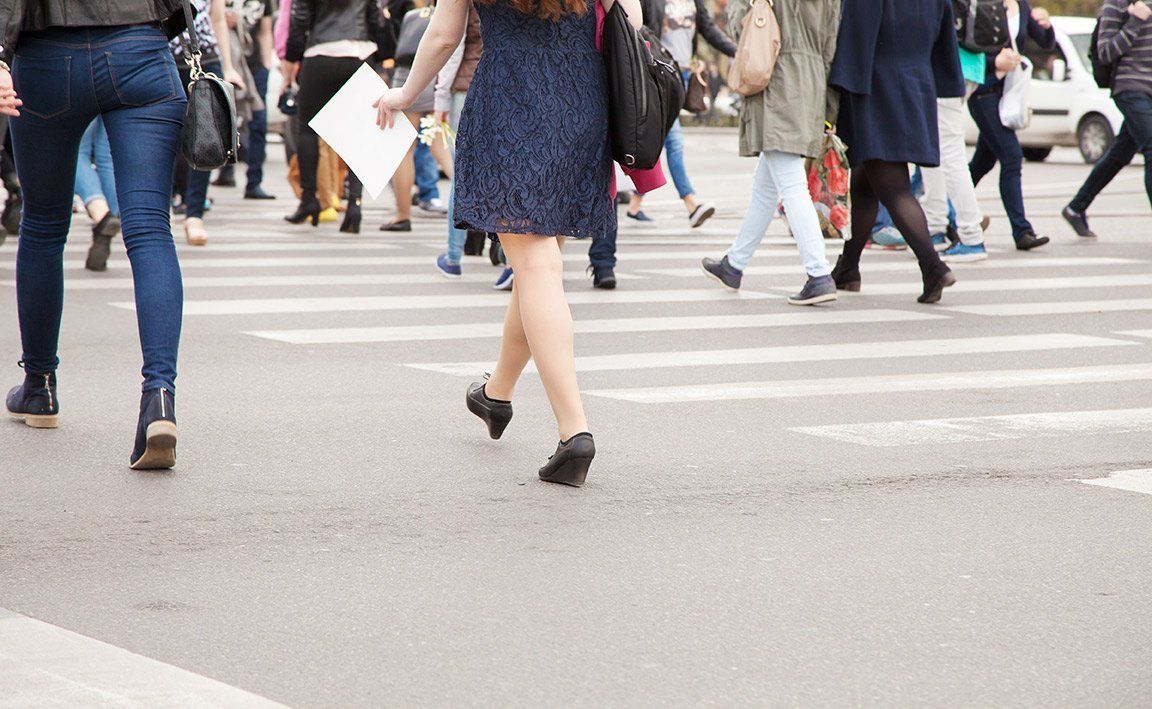 A large group of people are crossing a street.