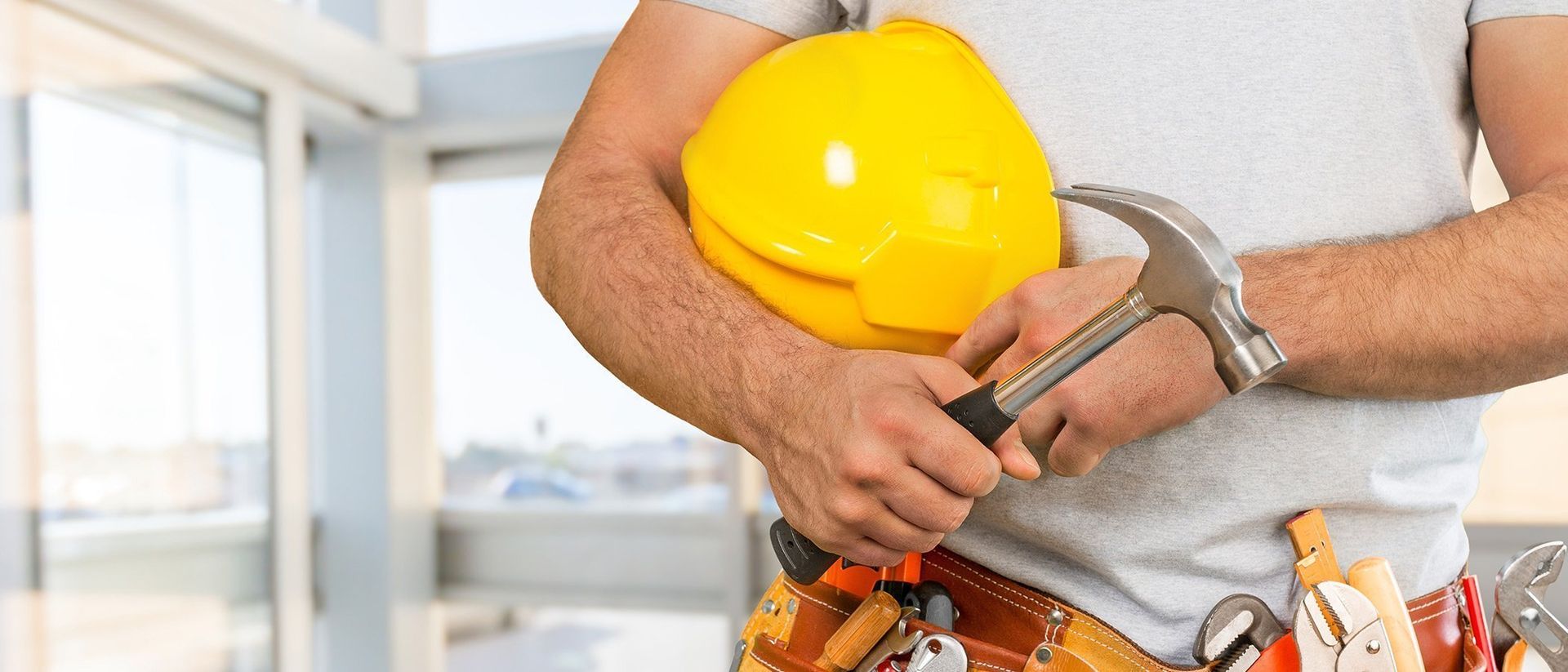 Handyman holding his tools with a tool belt on
