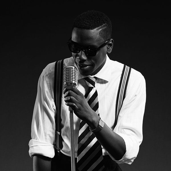 A black and white photo of a man singing into a microphone