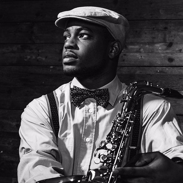 A black and white photo of a man holding a saxophone