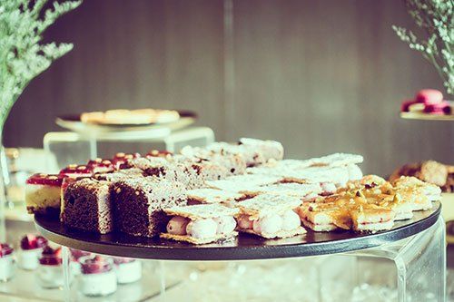 A selection of gourmet pastries and desserts arranged on a circular serving platter at a catered event.