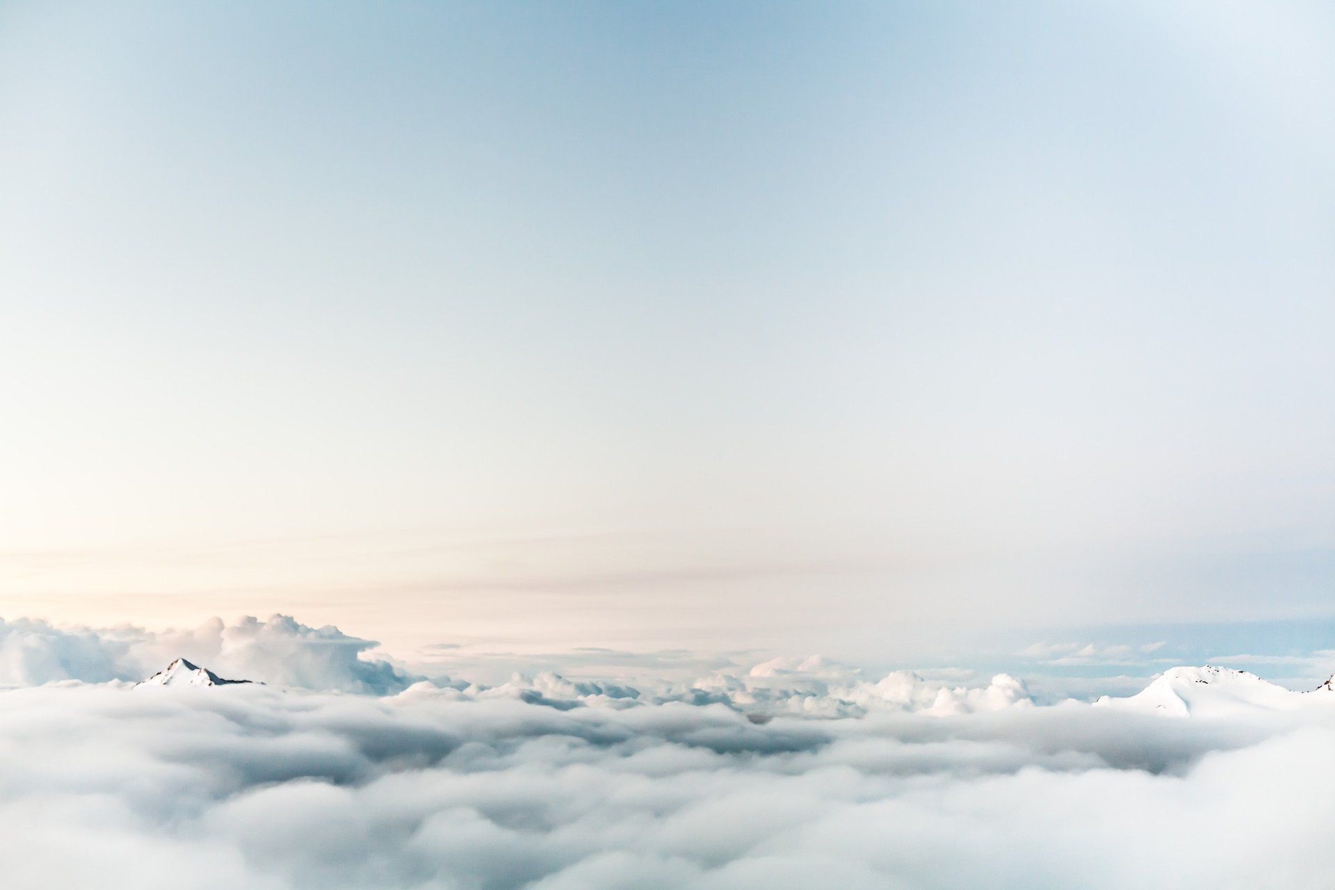A plane is flying through the clouds in the sky.