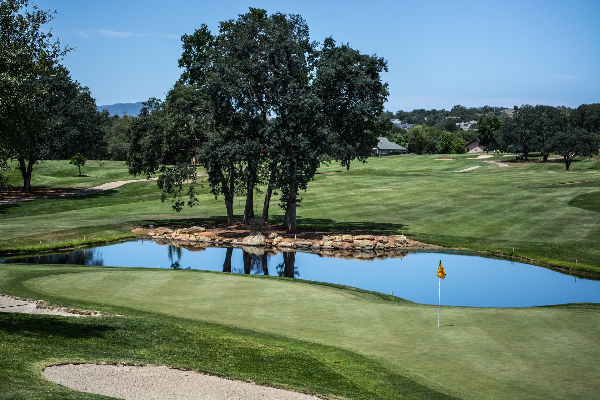 A golf course with a pond in the middle of it