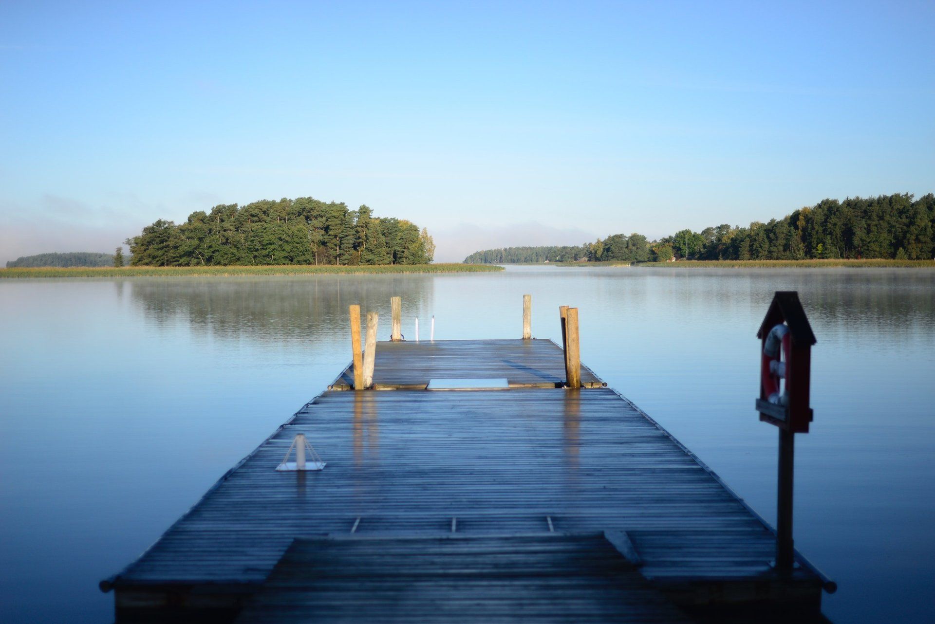 Ein hölzerner Steg liegt mitten in einem See.