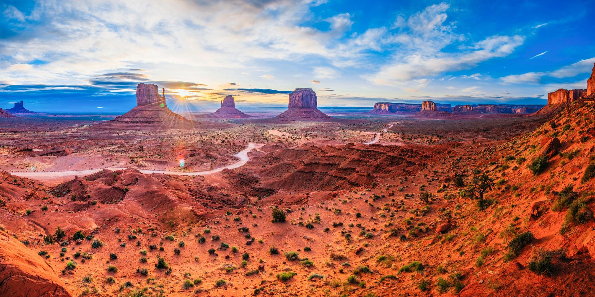 Desert landscape with red rock formations under a blue sky, Monument Valley.