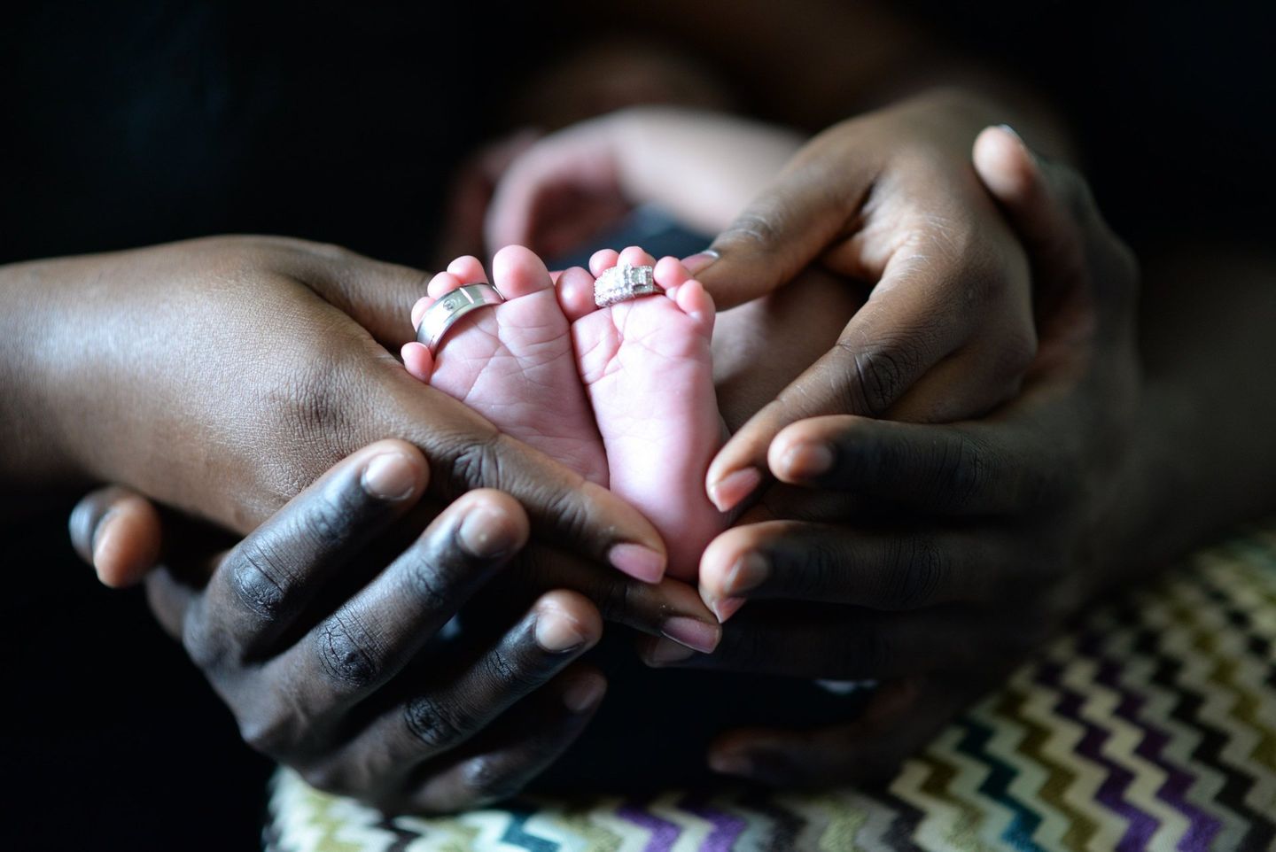 A person is holding a baby 's foot in their hands.