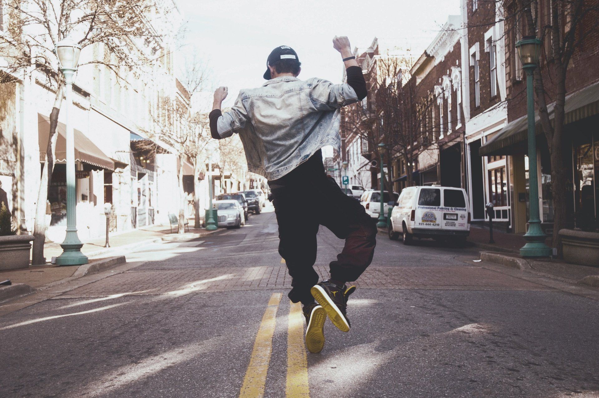 A man is jumping in the air on a city street