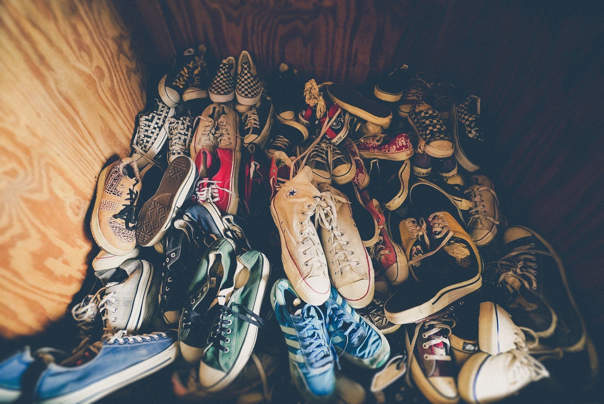 Pile of colorful sneakers inside a wooden box.