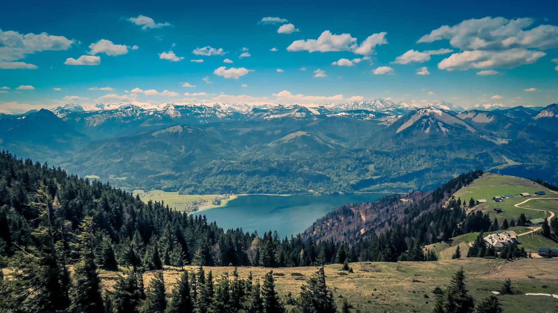 Inmitten der Berge liegt ein von Bäumen umgebener See.