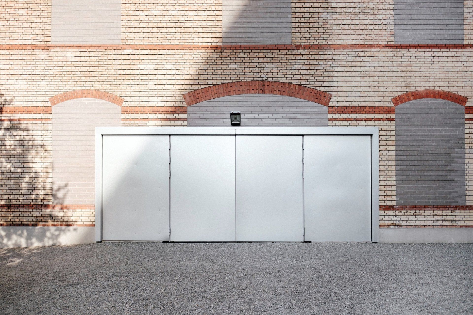 A large white cabinet is sitting in front of a brick wall