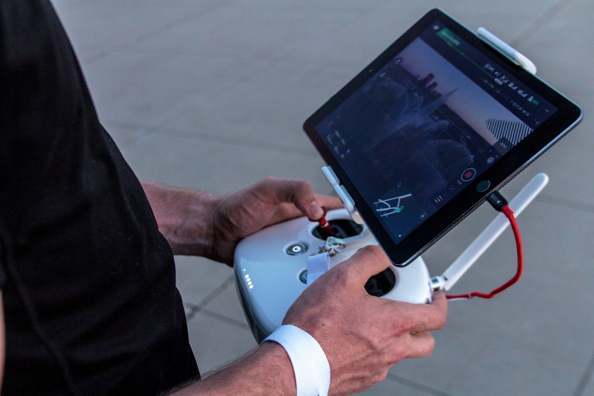 A man is holding a tablet and a remote control.