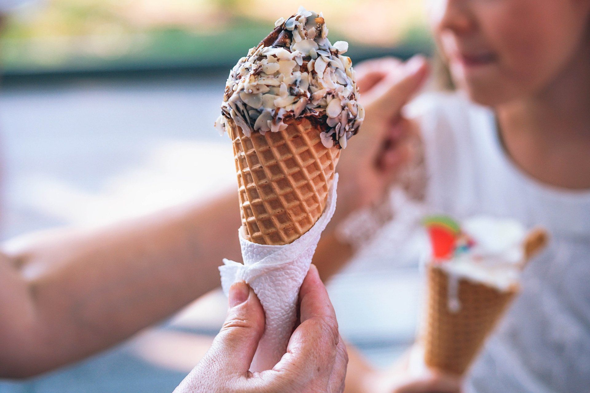 A person is holding an ice cream cone in their hand.