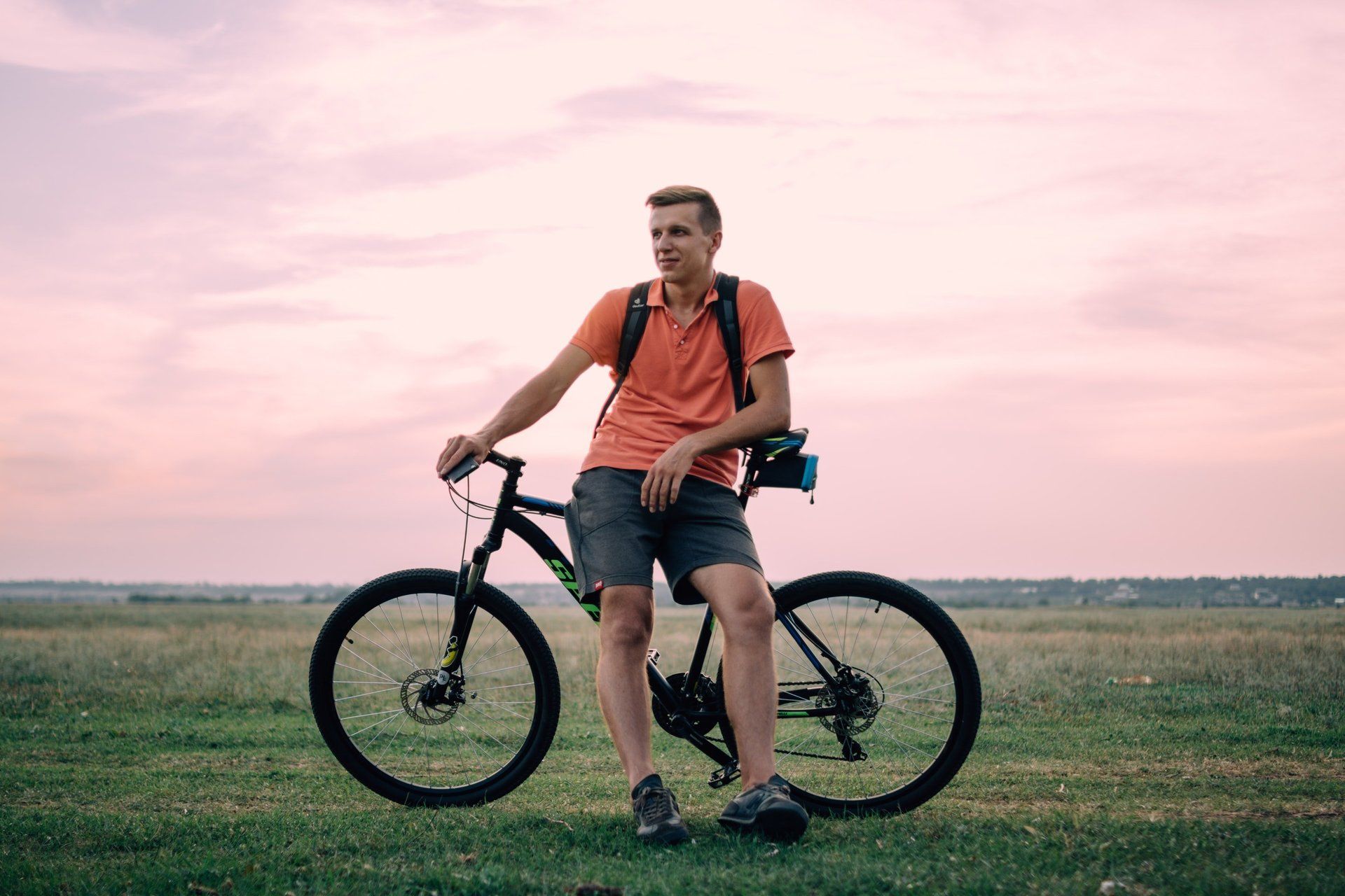 Man sitting on bike with healthy legs after varicose vein treatment