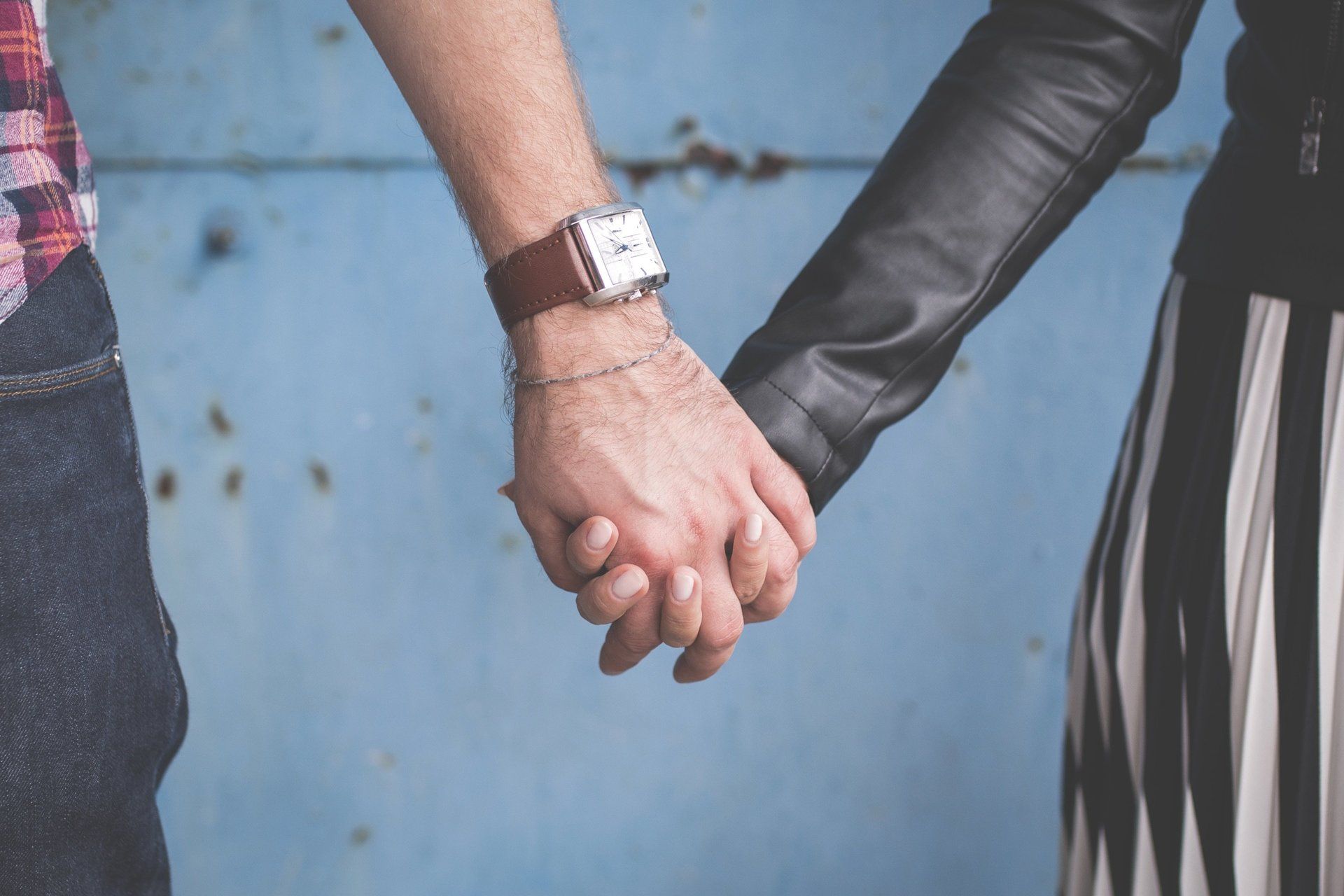 Un uomo che indossa un orologio tiene la mano di una donna
