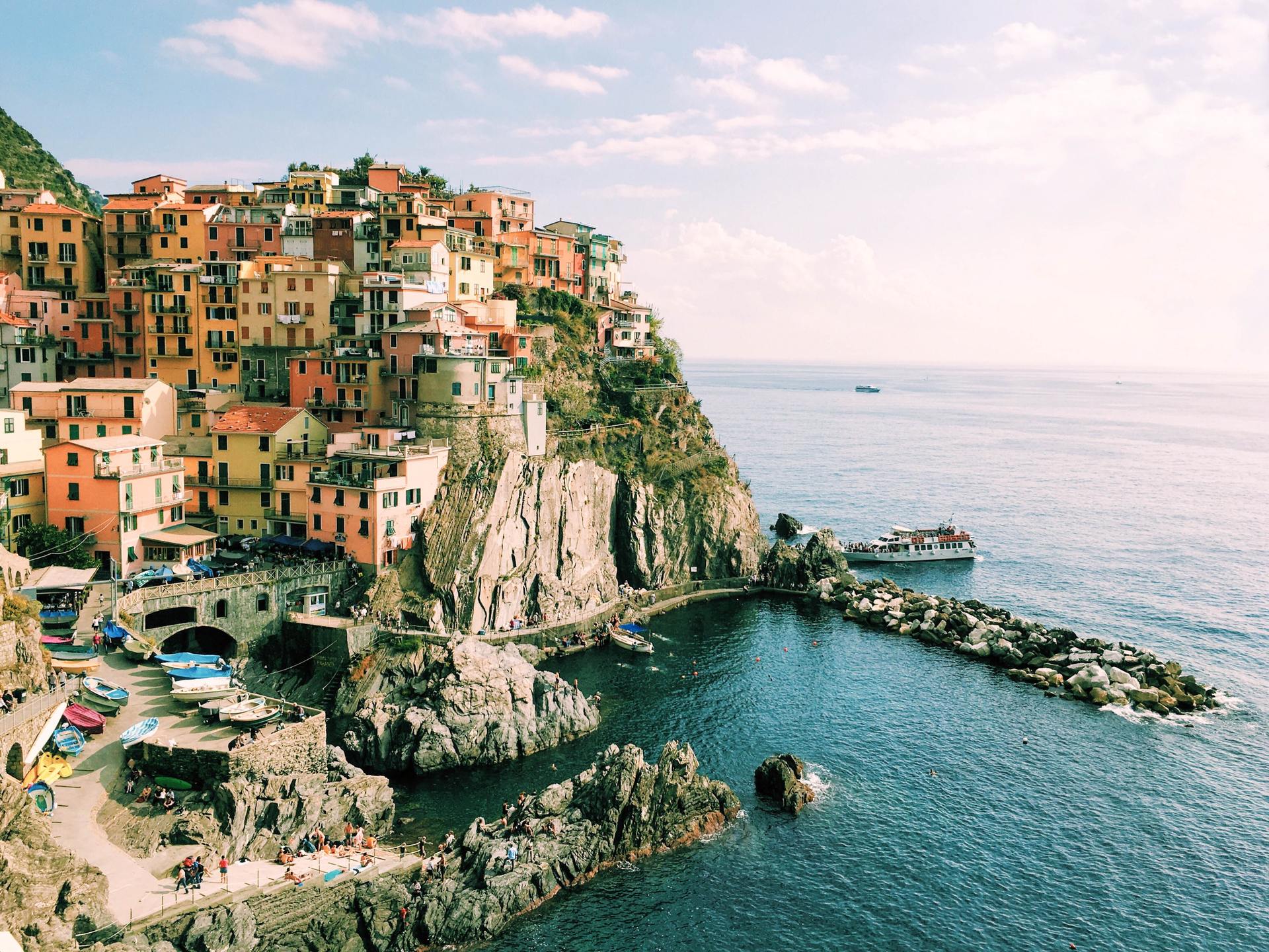 An aerial view of a small town on a cliff overlooking the ocean.
