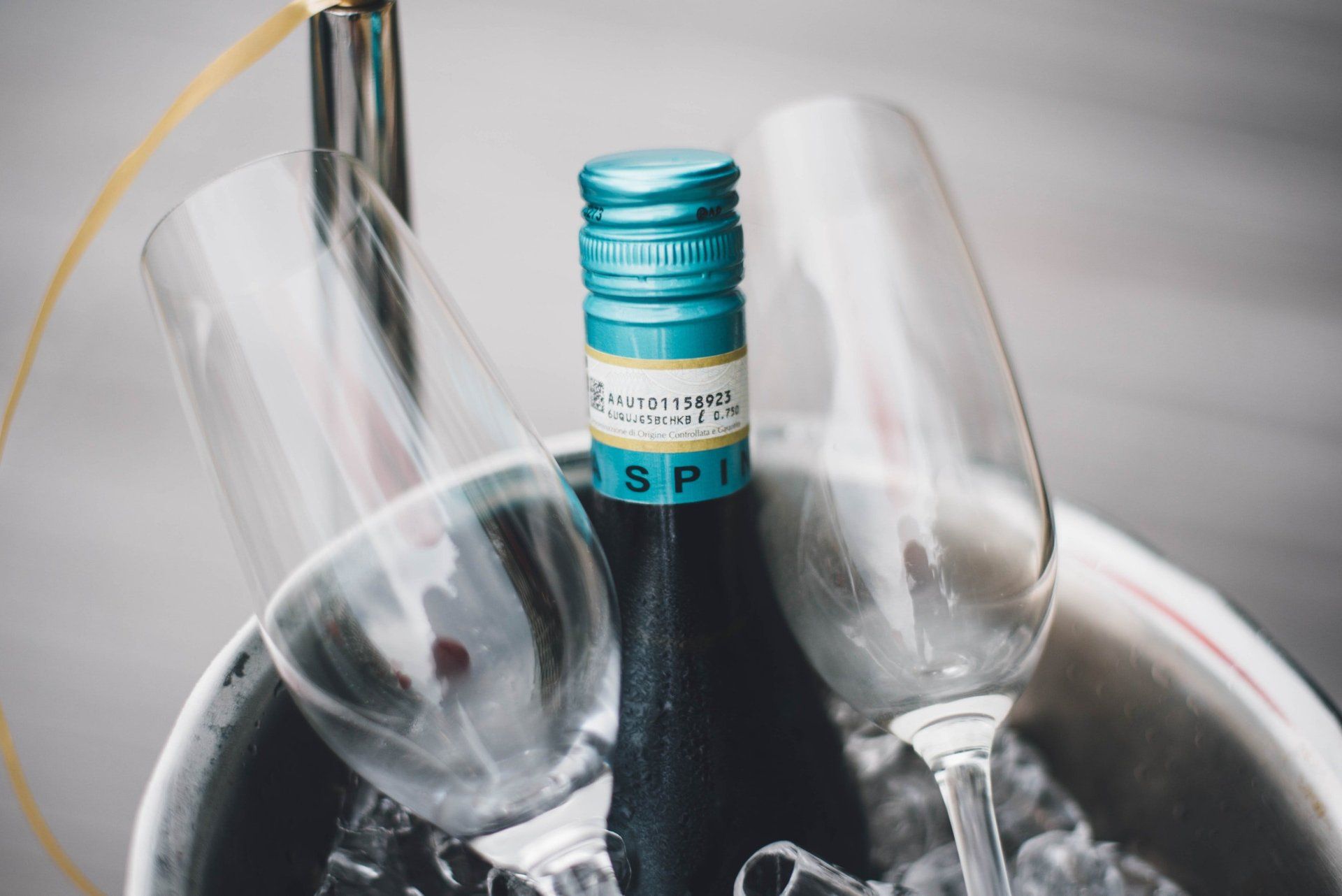 Une bouteille de vin est posée dans un seau de glace à côté de deux verres à vin.